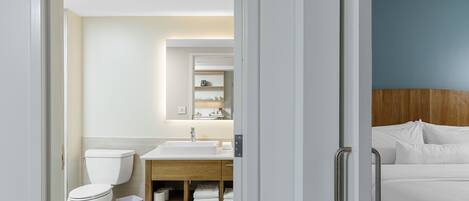 A modern bathroom with a toilet, sink, and mirror.