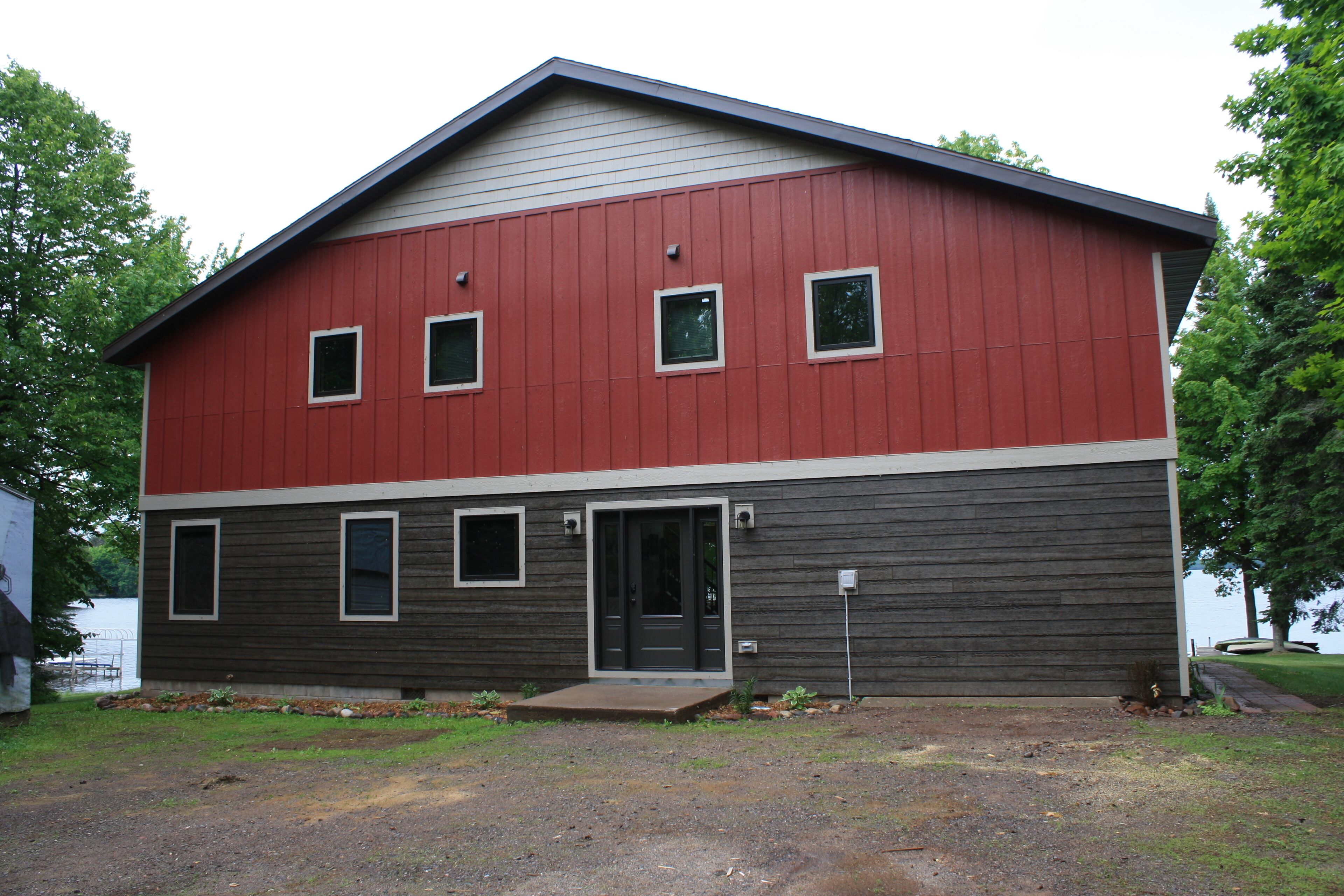A two-story building with a red upper section and a dark lower section.