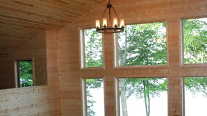 A wooden cabin with a balcony, large windows, and a ceiling fan. - Paradise Shores & Fish Galore ~your own private beach & dock! (Cable)