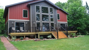 A two-story house with a covered deck and a staircase leading to the second floor. - Paradise Shores & Fish Galore ~your own private beach & dock! (Cable)