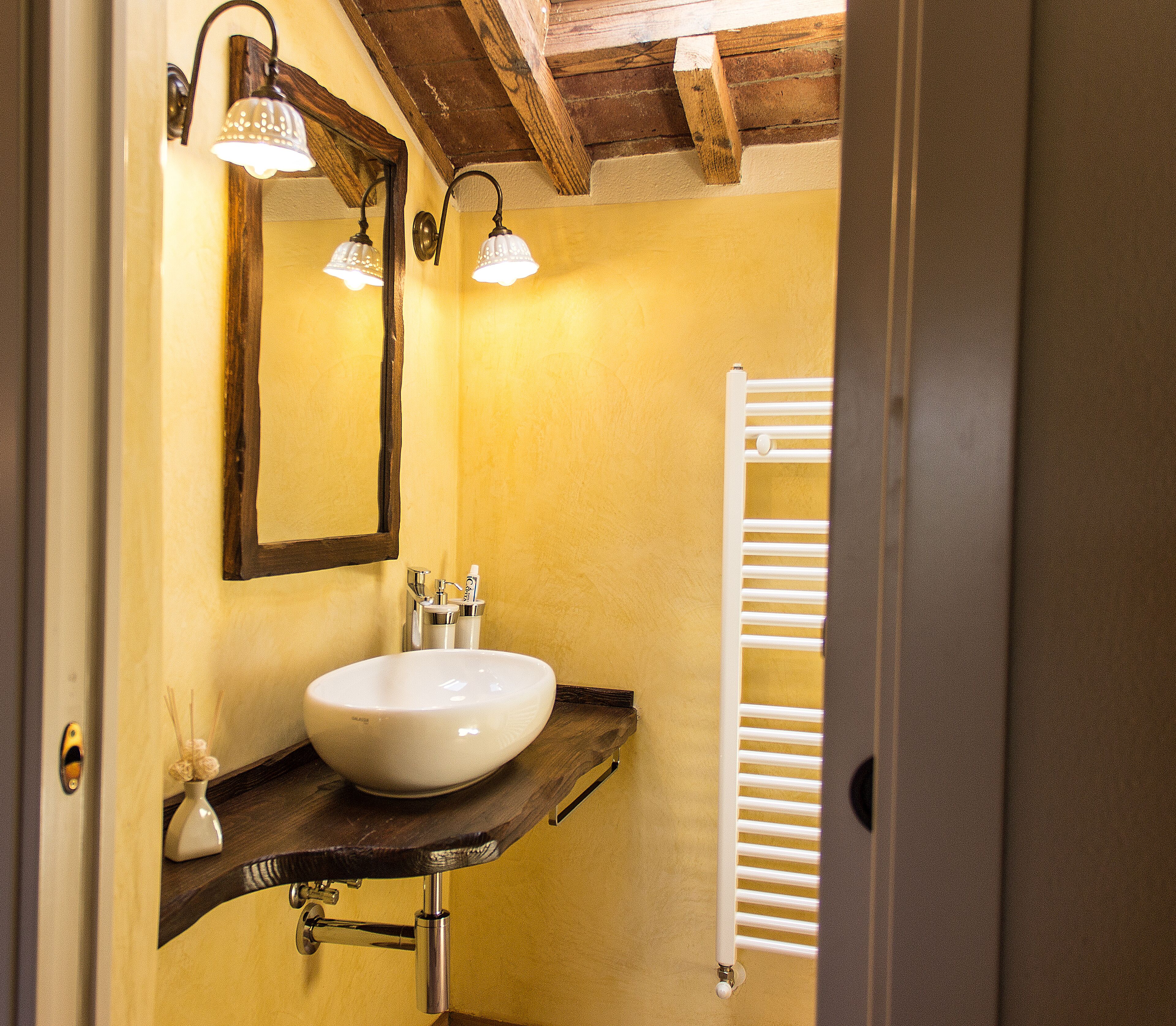 A bathroom with a white sink, a mirror, and a towel rack.