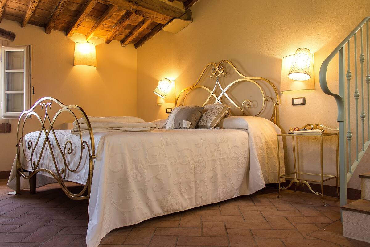 Ein Schlafzimmer mit einem Doppelbett, zwei Nachttischen und einer Lampe auf jeder Seite.