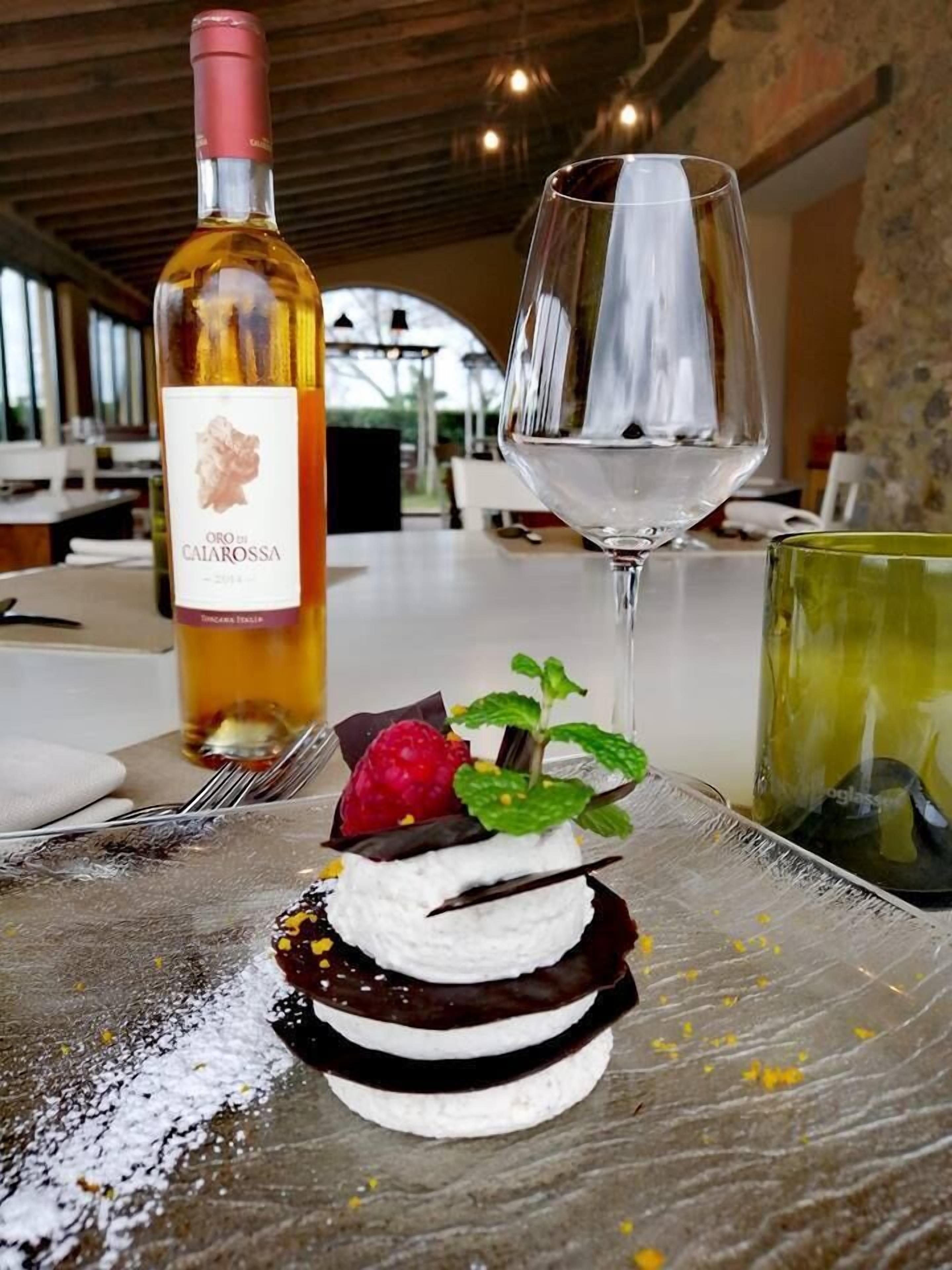 En dessert tillsammans med en vinflaska och ett vinglas på ett bord i en restaurang.
