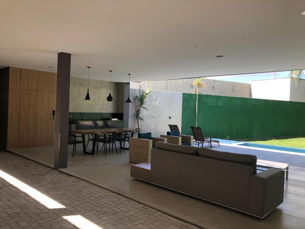 Uma área externa moderna com uma sala de estar, mesa de jantar e cadeiras.