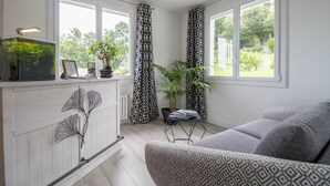 Una sala moderna con un sofá, una mesa de centro, una planta en maceta y un acuario.