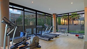 Ein modernes Fitnessstudio mit Cardiogeräten, einem Rudergerät und einer Bank.