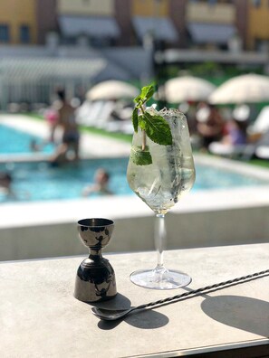 A cocktail glass with ice and mint leaves on a table near a poolside. - Hotel La Tavernetta (Ripalimosani)