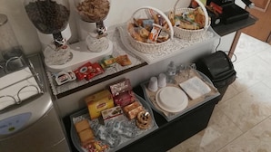 A buffet setup with various food items, including bread, snacks, and beverages. - B&B Main Street (Reggio Calabria)