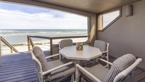 A covered outdoor seating area with a table and chairs, overlooking the beach. - Beautiful Oceanfront Penthouse ~ Incredible Views ~ Pool (Saint Augustine)