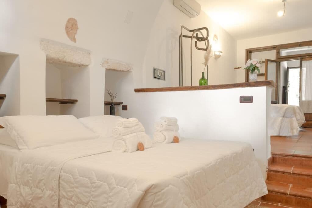 Une chambre à coucher avec un lit, une table de chevet et un miroir.