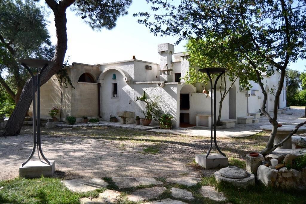 Une cour intérieure avec un bâtiment doté de fenêtres en arc de cercle et d’un chemin pavé de pierres.