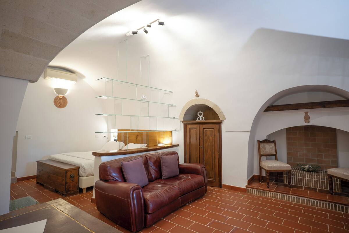 Ein gemütliches Wohnzimmer mit einer Ledersofa, einem Holzkabinett und einem Kamin.