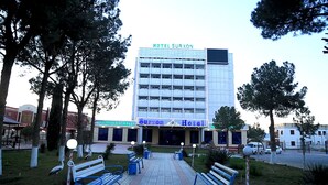 Um hotel com fachada moderna, vários andares e uma placa chamativa com a inscrição 