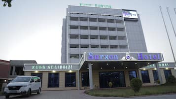 Un hotel con fachada moderna, un cartel que dice 'Surxon Hotel' y una entrada visible.