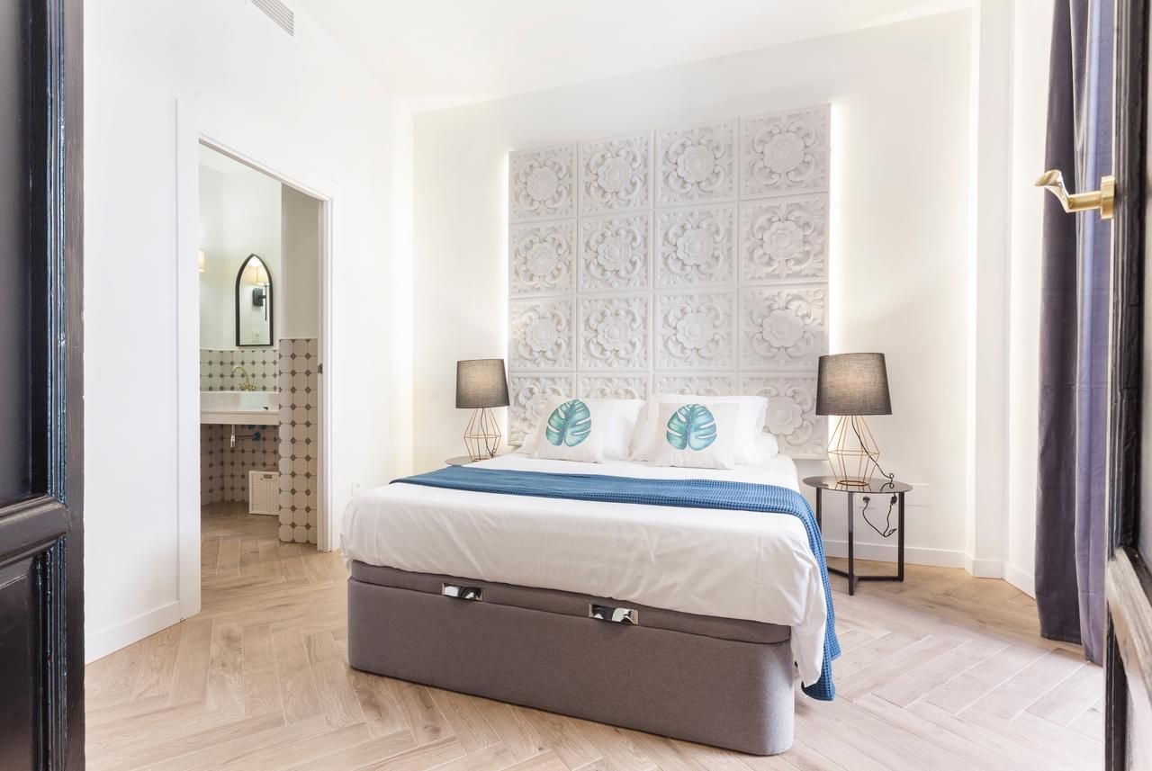 Une chambre à coucher avec un grand lit, une commode et une table de chevet avec des lampes.