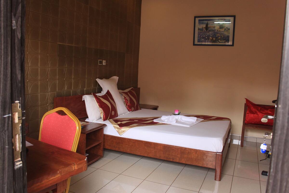 Ein Hotelzimmer mit einem Bett, einem Schreibtisch und einem Sessel.