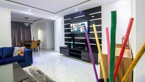 Una sala de estar moderna con sofá, televisor y mueble de entretenimiento.