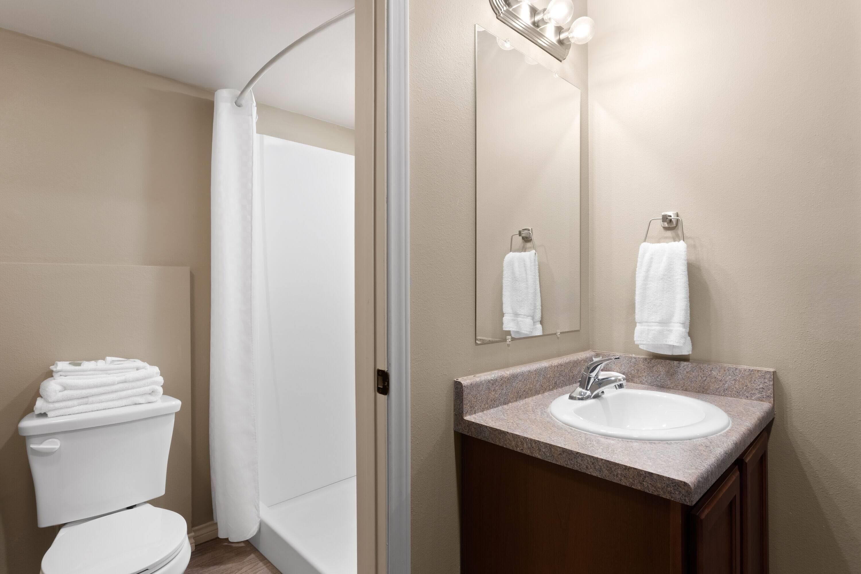 A bathroom with a toilet, sink, and shower.