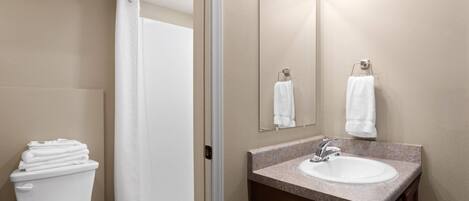A bathroom with a toilet, sink, and shower.