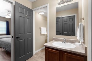Une salle de bain avec un lavabo, un miroir et un porte-serviettes.