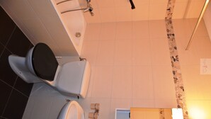 Et badeværelse med badekar, to håndvaske og et toilet.