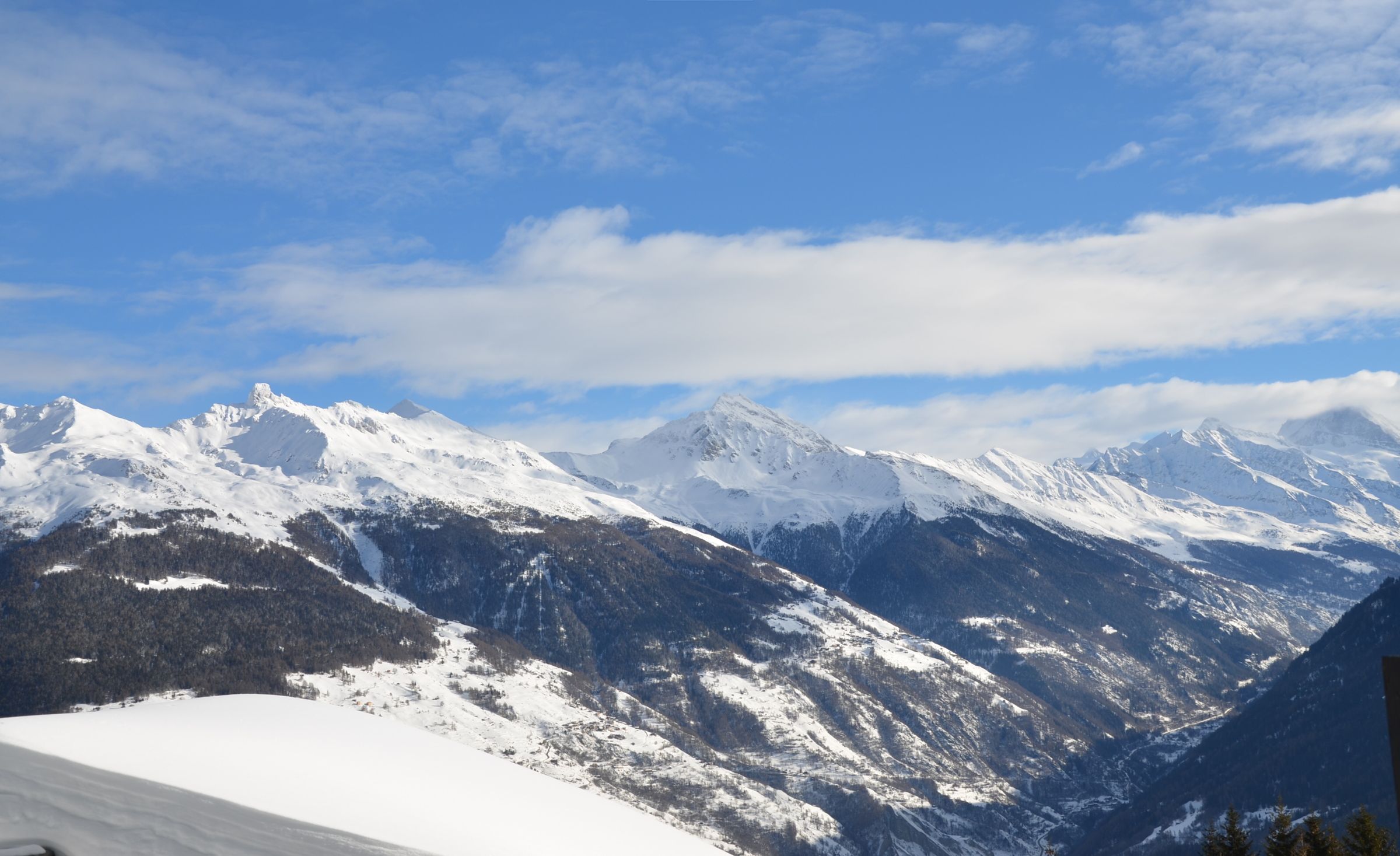 Un paisaje montañoso con picos nevados y cielo despejado.