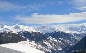 A mountainous landscape with snow-covered peaks and a clear sky.