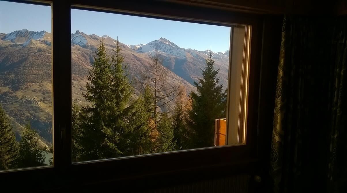 Une fenêtre donnant sur un paysage montagneux.