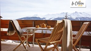 A wooden deck with a table and chairs, a teapot, and cups, overlooking snow-covered mountains. - Apartment for rent in les Collons (Thyon-Les Collons)