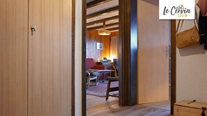 A wooden interior with a dining area, a red chair, and a table. - Apartment for rent in les Collons (Thyon-Les Collons)