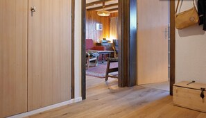 Un intérieur en bois comprenant un coin repas, une chaise rouge et une table.