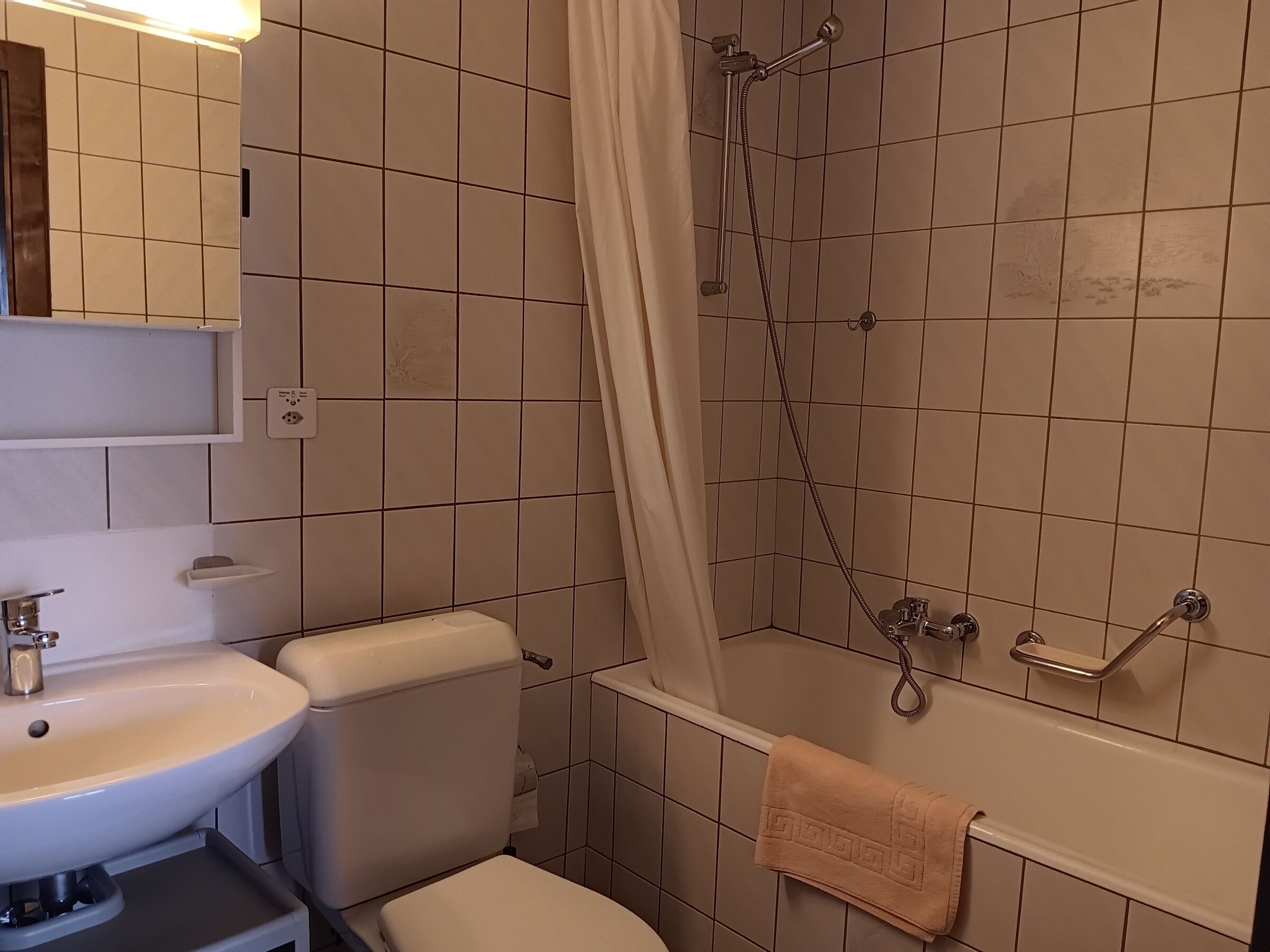 A bathroom with a toilet, sink, and bathtub.