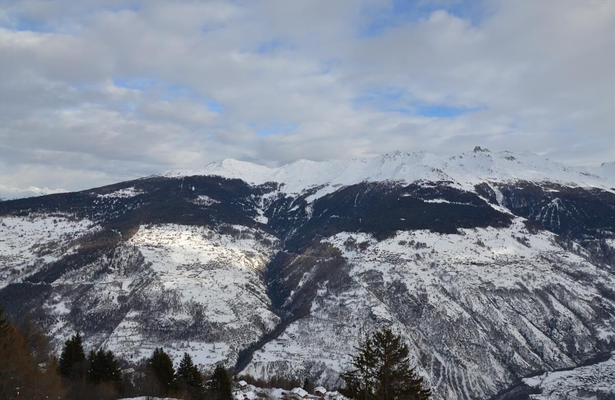Une chaîne de montagnes enneigées, avec une vallée au premier plan.