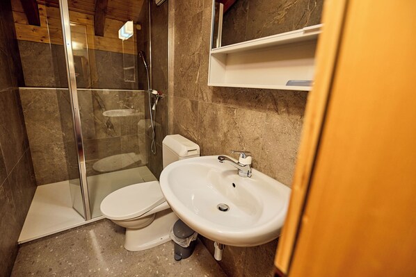 A bathroom with a glass-enclosed shower, a white toilet, and a white sink. - Nice flat for rent in Les Collons (Thyon-Les Collons)