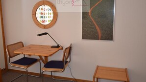 A room with a round window, a table with two chairs, a standing lamp, and a framed picture on the wall. - The Le Panorama building is located on the 1800 level of the Collons resort. Ideally located, it is (Thyon-Les Collons)