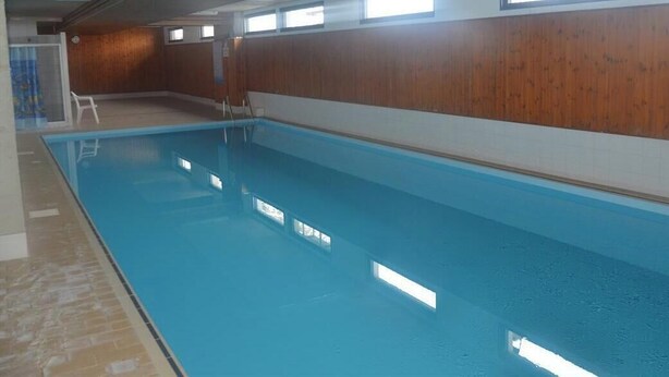 An indoor swimming pool with wooden walls, a tiled floor, and a clear ceiling. - The Le Panorama building is located on the 1800 level of the Collons resort. Ideally located, it is (Thyon-Les Collons)