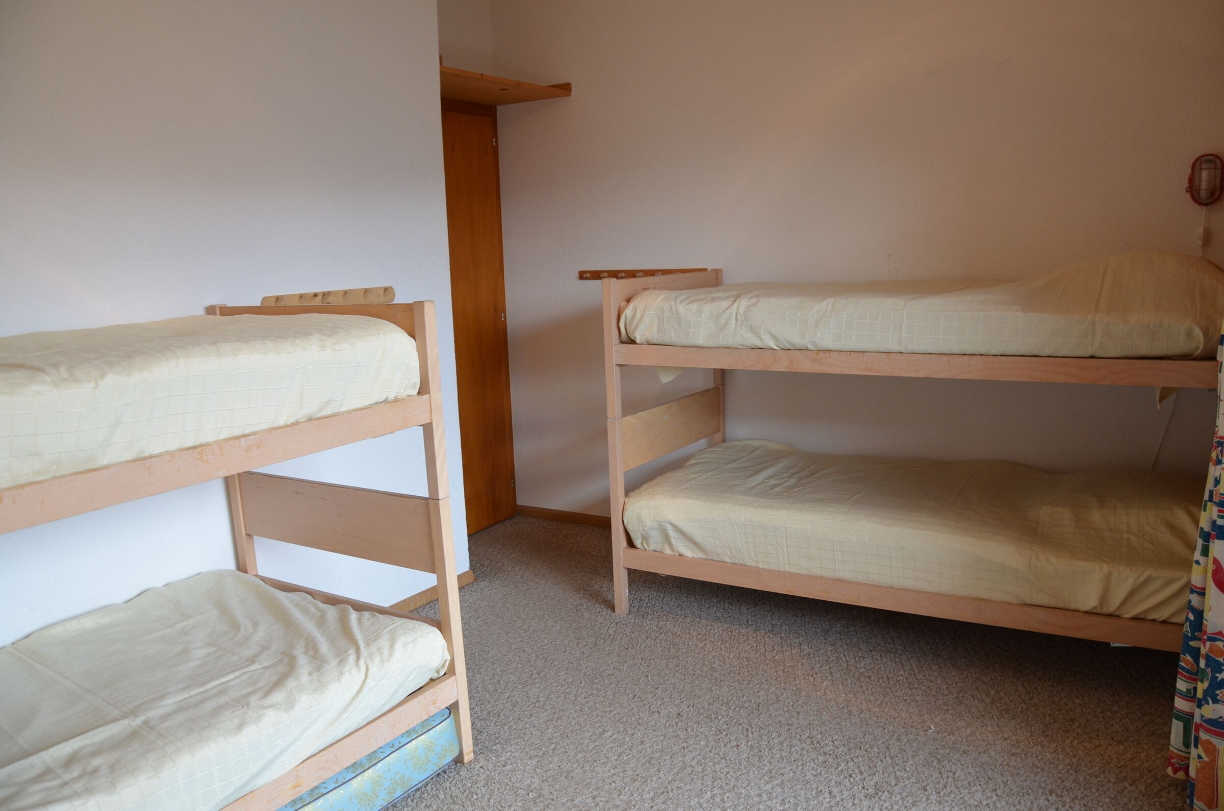 Habitación con literas, cabecero de madera y una cama individual.