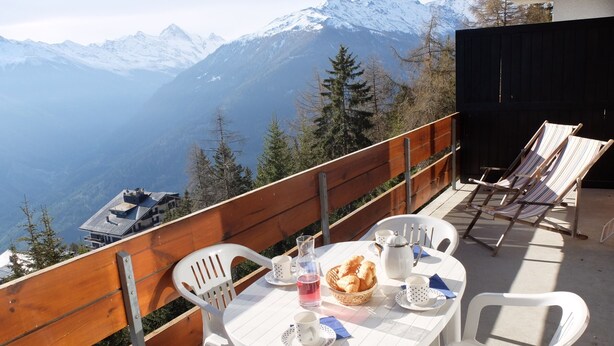 A terrace with a table set for two, overlooking a mountainous landscape. - Beautiful renovated apartment for rent in les Collons (Thyon-Les Collons)