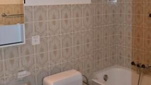 A bathroom with a toilet, sink, and bathtub.