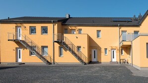 A yellow building with a staircase and a door marked '5a'. - Ferienwohnung Anke-Apartement 3 (Heinsberg)