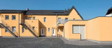 A yellow building with a staircase and a door marked '5a'.