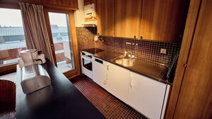 A modern kitchen with wooden cabinets, a black countertop, and a large window.
