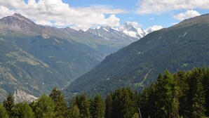 Un paisaje montañoso con un valle y zonas boscosas.