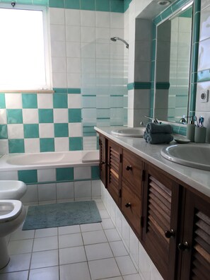 Tina con regadera, secadora de cabello, bidet, toallas 