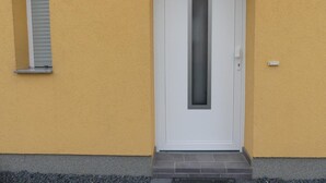 Um edifício amarelo com uma porta branca identificada com '3b'.