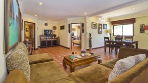 A living room with a sofa, a coffee table, and a dining area with a table and chairs. - Viewbor Villa - Pattaya Holiday House Walking Street (Pattaya)