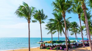 A beach with palm trees and umbrellas. - Viewbor Villa - Pattaya Holiday House Walking Street (Pattaya)