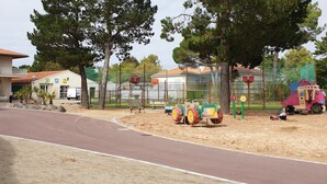 Un centre de remise en forme avec spa, une aire de jeux avec un parcours en tracteur et un espace clos avec des arbres.
