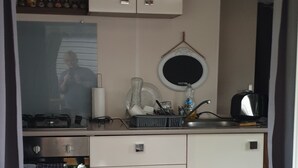 Une petite cuisine équipée avec une cuisinière, un évier et des placards de rangement.