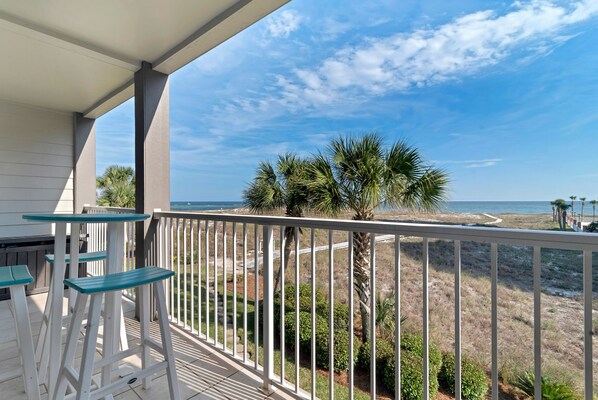 A balcony with white railings, a view of the beach, and a palm tree. - Gulf Front with Balcony- Perdido Pass-Affordable (Orange Beach)